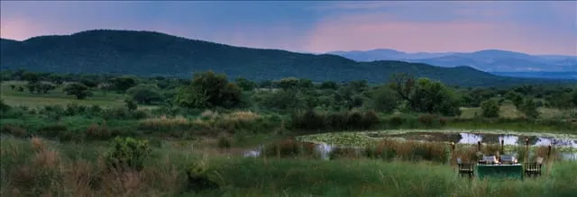 Dusk over the Rooiberg mountains, with a bush dinner set beside a lily-covered waterhole.
